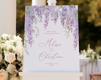 May include: A wedding welcome sign featuring a watercolour design of purple wisteria flowers. The sign reads "Welcome to our wedding Melissa and Christian October 17th 2026".