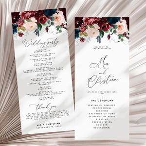 Puede incluir: Dos tarjetas verticales de programa de boda con un encabezado floral de rosas color burdeos, azul marino y rosa pálido con eucalipto. El texto incluye la lista de la corte nupcial, el orden de la ceremonia, los nombres Mia y Christian y la fecha.