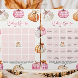 May include: A baby bingo game card with a watercolor pumpkin theme. The card features pink squares for bingo spaces and pumpkin illustrations. Text includes "Baby Bingo" and baby-related items.