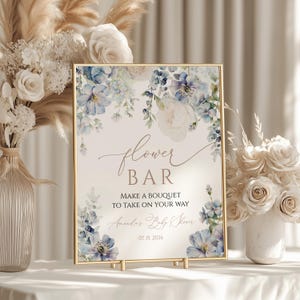Puede incluir: Un cartel con temática floral azul y blanca con el texto "flower bar" y "make a bouquet to take on your way". El cartel también incluye el texto "Amanda's Baby Shower" y la fecha "07.15.2026".