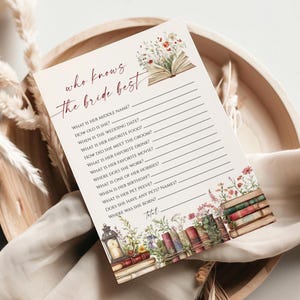 May include: A cream-colored bridal shower game card with the text "who knows the bride best" in burgundy script. The card features floral and book illustrations. Questions are listed below the title, with lines for answers.
