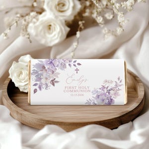 Puede incluir: Un envoltorio de chocolate blanco con un diseño floral morado. El envoltorio tiene el texto "Emily's First Holy Communion 12.15.2026" impreso en él.