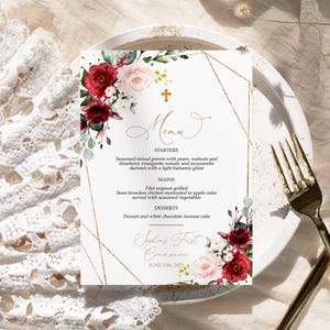 May include: A gold and white menu card with a floral design featuring red and pink flowers. The menu lists starters, mains, and desserts for a first communion celebration. The text on the card reads "Sophia's First Communion June 15th, 2021".