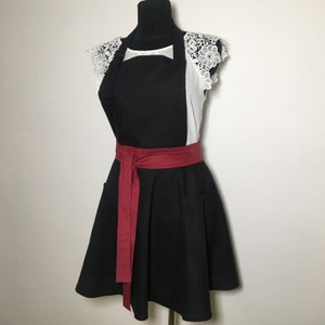 Black apron with red bow and pockets