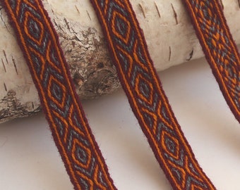 Bordure en laine tissée sur tablette. Reconstitution viking. Rouge, orange et gris clair.