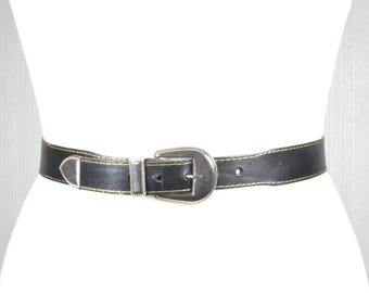 Cinturón vintage de cuero negro: hebilla plateada estilo western y pespunte en contraste.