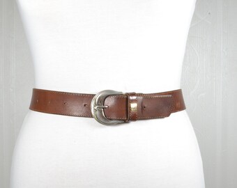 Cinturón de piel marrón con hebilla vaquera vaquera.