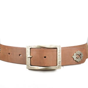 Vintage western brunt läderbälte med ko- och blommiga metallconchos