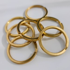 Puede incluir: Un juego de seis llaveros de metal de color dorado. Los anillos est&aacute;n entrelazados y dispuestos en una pila.