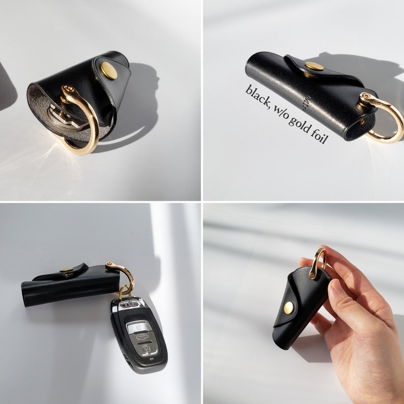 May include: Black leather key holder with a gold ring and a gold button. The key holder is folded in half and has a small pocket on the outside.