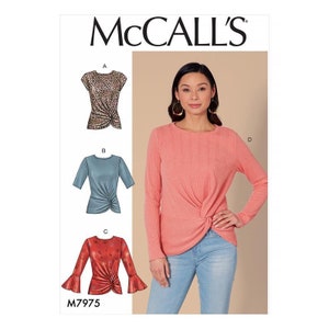 May include: McCall's sewing pattern M7975 for a top with a twist detail. The pattern includes four different views: a short-sleeved top with a leopard print, a short-sleeved top in a light blue color, a long-sleeved top in a coral color, and a long-sleeved top with bell sleeves in a red color.