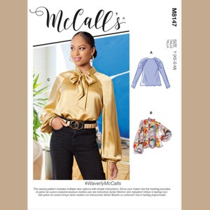 May include: A McCall's sewing pattern featuring a woman wearing a gold satin blouse with a bow tie and black pants. The pattern includes multiple view options with simple instructions. The text "#WaverlyMcCalls" is visible.