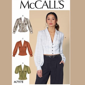 May include: McCall's sewing pattern M7978 featuring three blouse designs with various sleeve styles and button closures. The model wears a white plaid blouse with long sleeves and a V-neck. The pattern includes options for different fabrics and styles.