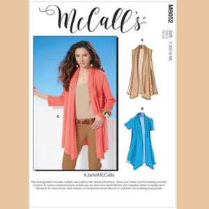 May include: McCall's sewing pattern M8052. The pattern includes multiple view options. The image shows a woman wearing a coral-colored cardigan. The pattern also features illustrations of a tan vest and a blue short-sleeved cardigan. The size is Y (XS-S-M).