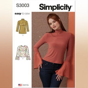 May include: Simplicity sewing pattern S3003 easy-to-sew features a mock neck top with long sleeves and flared cuffs. The pattern includes illustrations for a gold textured top, a floral print top, and a solid terracotta top shown on a model.