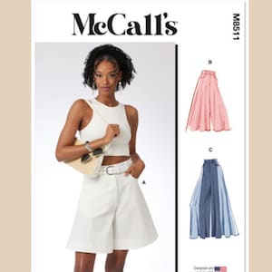 May include: McCall's sewing pattern M8511 for a pair of wide-leg shorts with a white belt. The pattern includes three different styles: a white pair of shorts, a pink pair of shorts, and a blue pair of shorts.