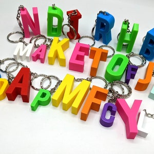 May include: A set of colourful letter charms with key rings. The letters spell out "SAM D MAKE TOF J D C Y L".
