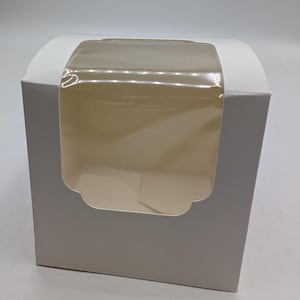 May include: A white cardboard box featuring a clear plastic window on the front panel. The box has a curved top design and a rectangular shape, providing a view into the interior space through the transparent film window.