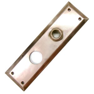 May include: A rectangular, antique-style door plate with a bronze finish. It features a circular hole for a doorknob and a smaller hole for a keyhole. The plate has rounded corners and four screw holes, showcasing a vintage aesthetic.