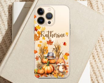 May include: Clear phone case featuring a fall-themed design with pumpkins, autumn leaves, and a fox. The name "Katherine" is written in gold script. The case is designed to fit a smartphone.