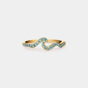 Puede incluir: Un anillo de oro con un diseño de ola engastado con piedras azules.