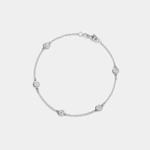 May include: A delicate silver bracelet featuring five round, clear gemstones evenly spaced along a fine chain. The bracelet has a simple clasp closure and is displayed against a plain white background, highlighting its elegant design.