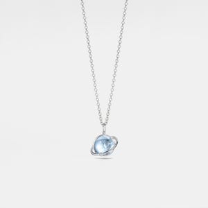 May include: A silver chain necklace with a pendant featuring a light blue gemstone sphere with a silver ring around it.
