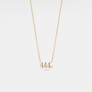 May include: A gold necklace with a pendant featuring the number 444 with a small diamond accent.