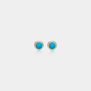 May include: A pair of gold stud earrings with round, turquoise-colored stones. The earrings have a simple, elegant design, with the turquoise stones set in a gold bezel.