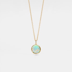 May include: A gold chain necklace with a round opal pendant. The opal is a light blue and green colour with a white base.