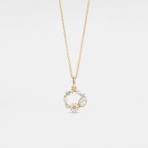 May include: A gold necklace with a delicate chain and a pendant featuring a circle of white gemstones and a single opal.