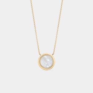 Peut inclure: Collier doré avec un pendentif circulaire. Le pendentif présente un centre en nacre et une bordure de petites pierres scintillantes. La chaîne est fine et le pendentif est centré.