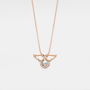 May include: A rose gold necklace with a delicate angel wing pendant featuring a small round gemstone surrounded by smaller diamonds.