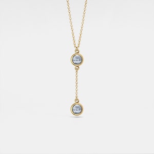 May include: A gold chain necklace with two round blue stones.