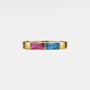 May include: A gold band ring with a pink and blue rectangular gemstone setting.