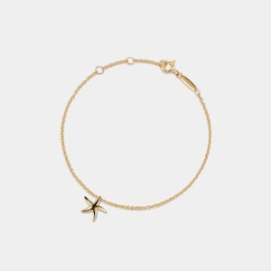 May include: A gold chain bracelet with a small starfish charm.