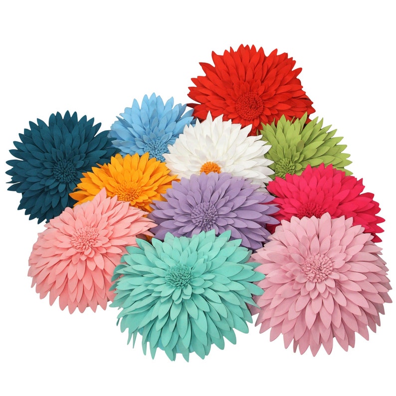 May include: A collection of colorful, decorative flower-shaped pillows in various shades, including red, blue, white, and pink. The pillows have a layered petal design and are arranged in a cluster.