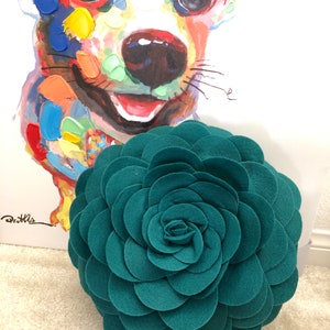 K&ouml;nnte beinhalten: Runder Kissen in Form einer Rosette aus blaugr&uuml;nem Filz mit 3D-Design.