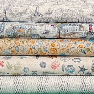 May include: Five fabric swatches with nautical themes. The top swatch features a white background with black and grey illustrations of sailboats, buildings, and a lighthouse. The second swatch features a white background with black and grey illustrations of sailboats, buildings, and a lighthouse. The third swatch features a beige background with brown and yellow illustrations of seashells. The fourth swatch features a white background with brown, red, and blue illustrations of seashells, starfish, and a compass. The bottom swatch features a white background with a repeating pattern of small blue dots.