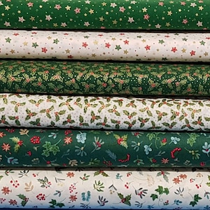 May include: A selection of Christmas-themed fabric rolls. The fabrics display patterns such as stars, holly leaves, and berries, in green, white, and red hues. The fabrics are likely cotton or a similar material, ideal for quilting or crafting projects.