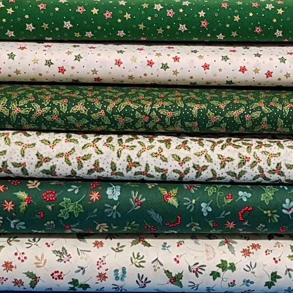 Puede incluir: Una pila de rollos de tela con temática navideña. Las telas presentan varios patrones, incluyendo estrellas, hojas de acebo y bayas, en tonos verdes, blancos y rojos. Las telas son probablemente de algodón o un material similar, adecuado para acolchar o manualidades.
