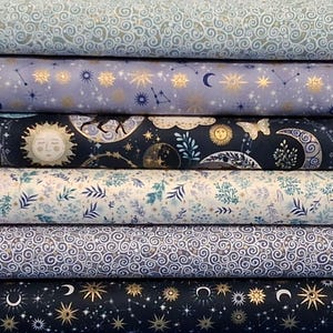 May include: A stack of six fabric bolts featuring celestial and botanical patterns. Designs include light blue swirls, purple with gold stars, dark navy with suns and moons, white with blue foliage, blue swirls, and dark navy with gold stars.