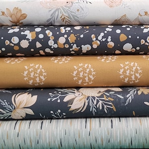 May include: Stack of five fabric swatches with different patterns. The top swatch is white with a floral design, the second is grey with gold splatter paint, the third is gold with a repeating pattern of birds, the fourth is grey with a gold floral design, and the bottom is light blue with a thin, horizontal stripe pattern.