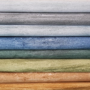 May include: A stack of eight wooden boards painted in various shades of blue, green, brown, and beige. The boards are arranged in a gradient from light blue to dark brown.