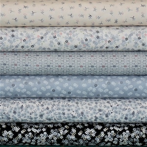 May include: Six rolls of fabric with different floral patterns in shades of blue and white. The fabric is perfect for quilting, sewing, and crafting.