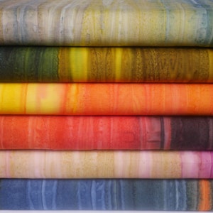 May include: Stack of six fabric swatches with different colour gradients. The swatches are layered on top of each other, with the top swatch being a light beige with brown and green streaks. The second swatch is a dark green with yellow and brown streaks. The third swatch is a yellow with orange and red streaks. The fourth swatch is a red with orange and black streaks. The fifth swatch is a light beige with pink and brown streaks. The bottom swatch is a blue with white streaks.