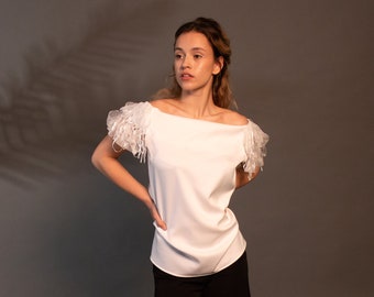 Haut décoré d'une bandoulière élégante blanche! Haut d'été pour femme. Un confort décontracté et durable pour un chic au quotidien. Vêtements pour femmes par Muzeva