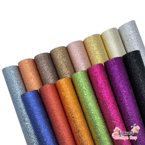 May include: A collection of 15 rolls of glitter faux leather in various colors, including silver, gold, copper, green, blue, purple, and black. The faux leather has a textured, sparkly finish.