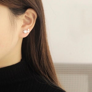May include: Three silver star shaped earrings