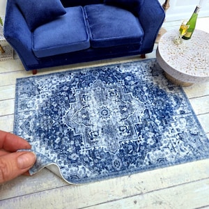 Könnte beinhalten: Ein blauer und weißer Teppich mit Muster und einem Used-Look. Der Teppich hat ein zentrales Medaillon-Design und ist perfekt, um einem Wohnzimmer oder Schlafzimmer einen Hauch von Boho-Stil zu verleihen.